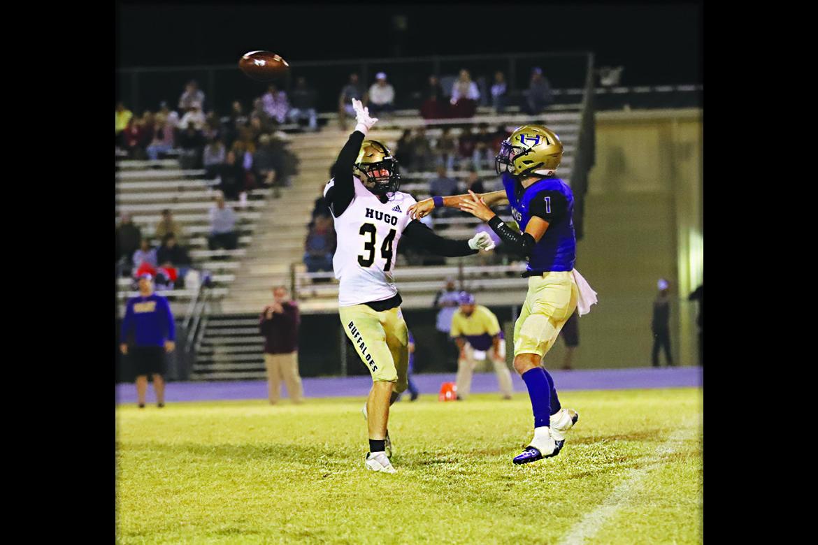 BUFFALO DEFENDER PIERSON EVANS forces Heavener’s quarterback to hurry his pass during District 2A-6 football action Thursday in Heavener. The Buffaloes hammered the Wolves, 62-39 to solidify their third place in the District. Hugo News Photo / KELLI STACY
