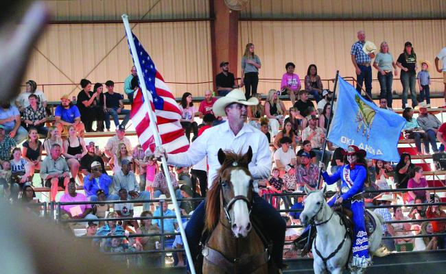 Oklahoma Governor Kevin Stitt presents the American Flag during the Grand Entry of the 62nd annual Hugo PRCA Rodeo Saturday evening.