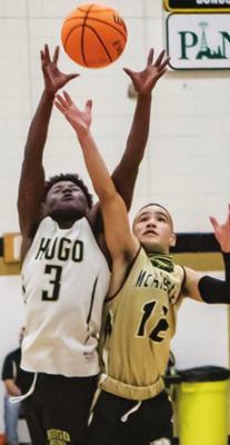 CASEY BENSON (right) takes the ball to the rack for the Hugo Buffaloes as a McAlester Buffalo defender tries to cut him off. Benson scored 13 to lead the Buffaloes against the Durant Lions in an earlier game. Hugo News Photo / Bobby Hamill