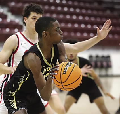 DAE’MARRIUS FREEMAN works the ball for the Hugo Buffaloes into a soft spot in the opposing team’s defense during weekend tournament action in Ada. Hugo opens their 2024 home basketball season this Friday against Broken Bow with JV tipping off at 4 p.m. Hugo News Photo / Kelli Stacy