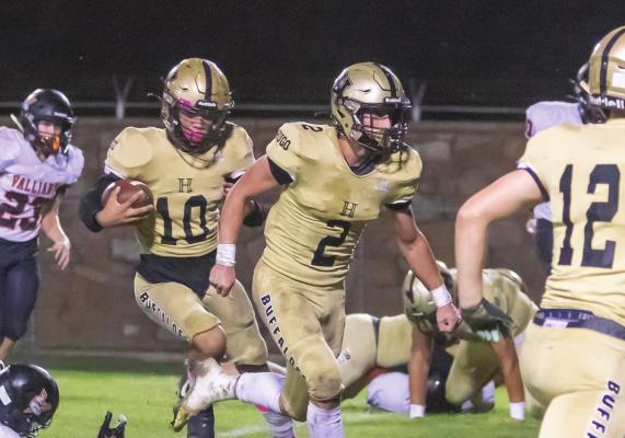 LaMARCUS DAVIS continues to put more than 100 yards of rushing into his official game stats so far this season, to lead the Hugo Buffaloes running attack. Above, Davis follows Ashton Barnett through a big hole in the offensive line as they check out a downfield block by teammate Cam Holt. Hugo News Photo / Bobby Hamill