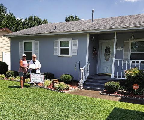 Iris Garden Club Yard of the Month belongs to Kathy Harris, at 1108 Cardinal in Hugo. The immaculate yard features flowers, shrubs, a beautiful decorative mailbox, light and porch. Presenting the certificate and sign is Harolynn Wofford. Photo Courtesy / Sammye Thacker