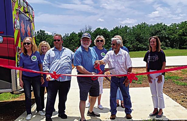 Ch ris Lynch and Joe Williams cut the ribbon officially opening the Fort Towson helipad. Others present were (l-r) Judy Fuhrhop, Stacy Marks, Jay Marks, Janice Medlock and far right Louisa Kassel of the St. Joseph’s Community Foundation.