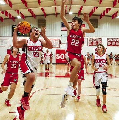 SOPER’s CAYSON WILLIAMS takes the ball to the goal during a recent home court battle with Clayton. Teammate Devon Edge hustles in for a possible rebound. Hugo News Photo / Bobby