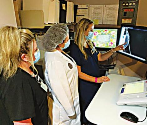 Mammogram Technologist Ashley Kennedy, R.T. (R)(CT)(M) B.S., shows Dr. Chisum-Price and Radiology Physician Assistant Ami Hess the Magseed on the image of the breast.