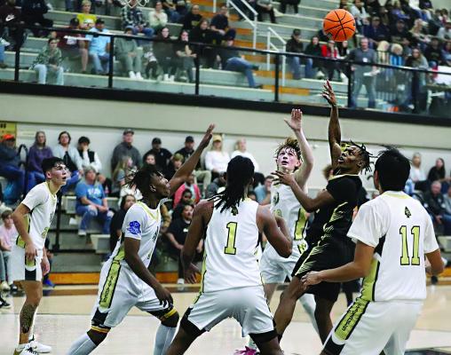 QUINCY SHELTON found himself in the paint surrounded by the entire Broken Bow Savage basketball team in tournament basketball action last week... but that didn’t stop him from putting up a two-point shot for the Hugo Buffaloes. The Savages out-scored Hugo 7060 to take the W, but Hugo will get another shot at them later in the season. Hugo News Photo / Kelli Stacy