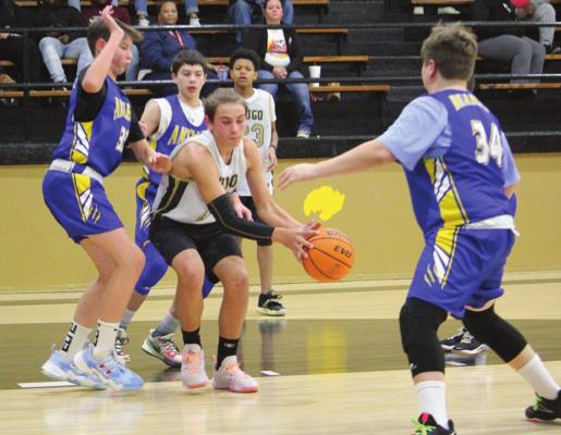 JAYKA SANTILLAN takes a pass inside the paint and makes a move on the goal against the Antlers seventh-grade Bearcats Monday in Hugo. Putting defensive pressure on Santillan is Antlers’ Max Duncan, Kobe Tabor and Blake Skaggs. Antlers won the game 25-16 with Duncan booking three points and Skaggs 2. Hugo News Photo / Stan Stamper