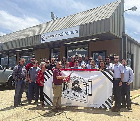 The Hugo Area Cha mber of Commerce held a ribbon cutting ceremony for Keyocks Cleaners last week. Pictured: Will Smith, of Kiamichi Opportunities, cuts the ribbon while Keyrocks employees and Chamber representatives assist. The business is located at 1302 E. Jackson St.