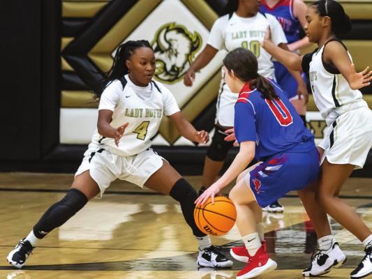 ZION BILLS, a junior for the Hugo Lady Buffs, throws a barricade in front of a Durant Lady Lion during Hugo’s first home game of the 2021 season. Assisting Bills is teammate Sha’Tiya Akins as Kelicia Cook closes in from the flank. Hugo News Photo / Bobby Hamill