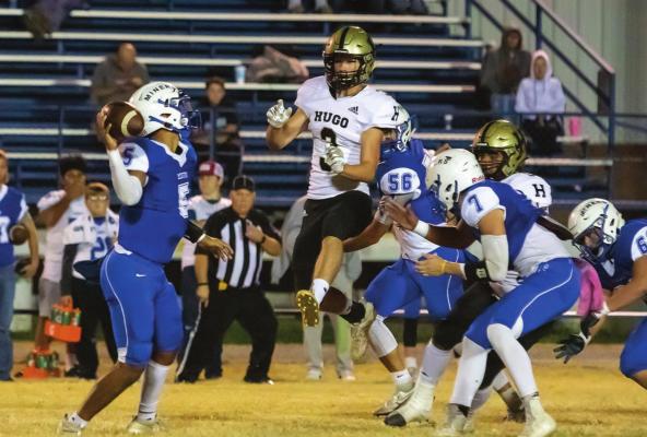 BUFFALO DEFENDER CAMDEN HOLT blasts through the Hartshorne Miner line and forces quarterback Bryson Cervantes to hurry his pass during last week’s District contest against the Hugo Buffaloes. Later in the game Holt put a solo tackle on the Miners QB forcing a fumble that teammate Pierson Evans scooped up for a Buffalo touchdown.