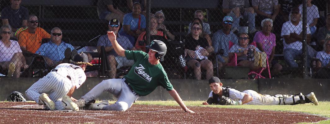 CATCHER BRENDAN ROARK flips the ball to teammate Rick Marshall but not in time to stop a Tiger score. Brian Moore Photo