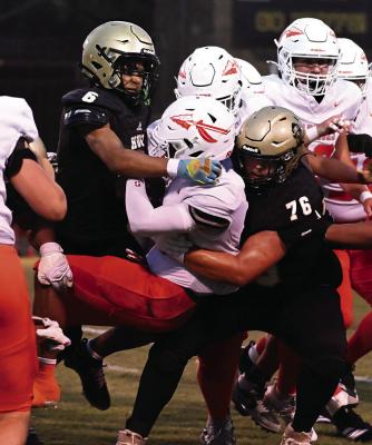 HUGO’S KAMDEN BOSTIC was the team’s leading tackler during the Buffaloes’ first game of the season against No. 8-rated (Texas) Honey Grove Warriors. Above, Bostic joins teammate Zane Allen in pulling down a Honey Grove ball carrier. Hugo News Photo / Stan Stamper