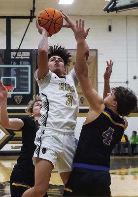 DAIQUAN LENNOX battles past three Paris North Lamar defenders into the paint as he puts up two points for the Hugo Buffaloes in last week’s clash in Hugo.