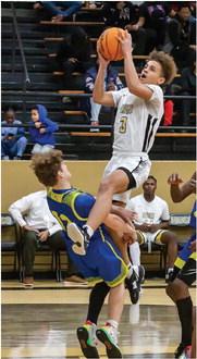 DA’MARION RAMSEY soars into the paint and draws a foul form a North Lamar defender during last week’s holdiay game at Simon Parker gym. Ramsey scored six points enroute the JV’s 63-59 win. (RIGHT) KORY MITCHELL hustles down a loose ball for the Hugo Buffaloes JV team against Paris North Lamar. Mitchell had nine points for the Buffaloes. Hugo News Photo / Bobby Hamill