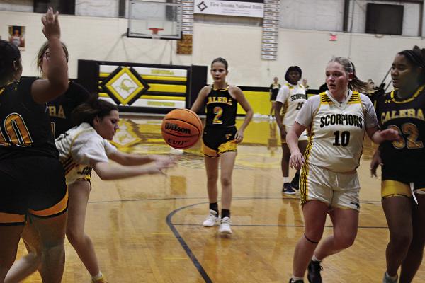 BOSWELL’S BRYLIE STEVENS battles through a double-team defensive effort by Calera to get a pass off to teammate Rilee Ribera during recent basketball action on the Scorpions’ home court. Brian Moore Photo