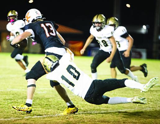 JACOBY TEAGUE catches a Roland ball carrier from behind and wrestles him to the ground as several of his teammates close in for the assist. (BELOW)