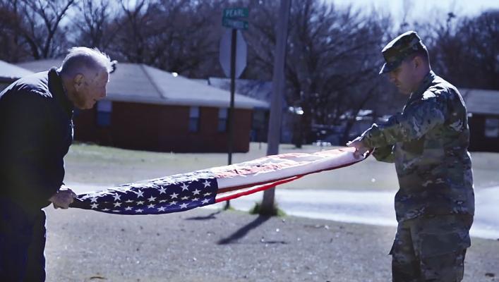 CPT Greg Gardner and the late retired SGM Billy G. Gardner fold the American flag.