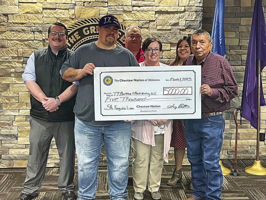 William and Ashley David Thompson, owners of T7 Backhoe &amp; Rock Hauling, accept a $5,000 check from District 8 council member Perry Thompson.