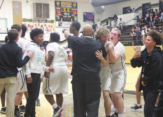 PIERSON EVANS celebrates with his teammates and hugs Coach Demontre Akins after Evans dropped the winning shot in front of the second overtime buzzer Hugo News Photos / Kelli Stacy