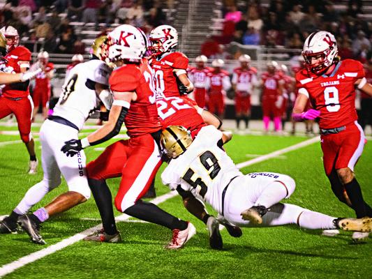 TOUGH DEFENSE! Hugo Buffalo defender Jayce Trantham goes to work in the trenches to pull down a Kiefer runner for a short gain as teammate Quincy Shelton also moves in for the assist. (BELOW) JONATHAN CHAVEZ catches a Trojan ball carrier from behind as teammage Jacoby Teague arrives to assist. The Buffalo defense kept the team in the game against Kiefer until the final seconds of the game.