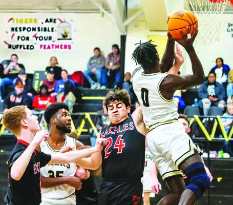 OMAR GARDNER breaks through the Victory Life defense and puts up two of his 12 points for the Fort Towson Tigers during last week’s home battle against the Eagles. Also battling defensively in the paint for the Tigers is teammate Deshon Rose.  Hugo News Photo / Bobby Hamill