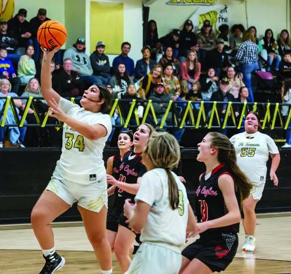 MADISON HUDSON outruns the Victory Life Lady Eagle defenders and puts up two points for the Fort Towson Lady Tigers during a recent home court battle. Racing down the court to assist are teammates Taylor McKnight and Hailey Wyatt. Hugo News Photo / Bobby Hamill