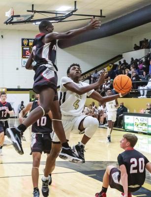 AMARIAN MAYTUBBY launches a shot around the leaping arms of an Idabel defender in the Buffaloes’ incredible OT win last week. It was a classic battle between the two closely-matched teams. Hugo News Photo / Bobby Hamill