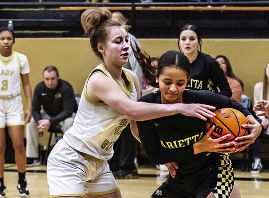CALLISTA KELLEY plays some “get in your face defense” against a member of the Marietta Lady Indians basketball team in the District Tournament Friday. Kelley scored seven points for the Lady Buffs. Hugo News Photo / Bobby Hamill