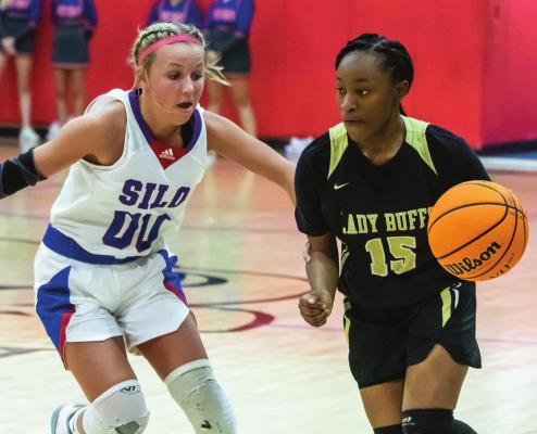 ZION BILLS drives the seams in the defense of the Silo Lady Rebels during recent basketball action at Silo. Bills hit a long-distance trey in the fourth quarter for the Lady Buffs, but it wasn’t enough to overcome the Lady Rebels, who took the game 34-41.