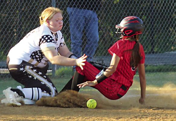 BRANTLEY HILLBORN waits for the throw to third, but it’s not earlier enough to catch this Idabel Lady Warrior before she sends up a cloud of dirt sliding safely into third. Brian Moore Photo