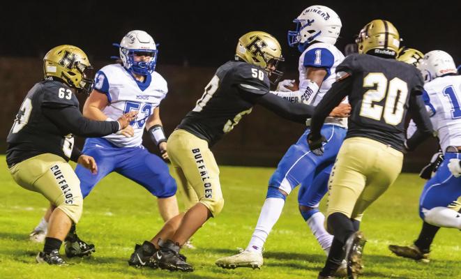 DEFFENSIVE SWARM — Hugo Buffalo defender Isaiah Greer (50) is joined by Aaron Gilley (20) and Ethan Bigfeather (63) to bring down a Hartshorne runner during the Buffaloes’ big 32-20 District victory Friday on Buff Parker Field. The win closed out the regular season for Hugo at 7-3 and earned them a berth in the State Playoffs Friday in Tulsa. Hugo News Photo / Bobby Hamill