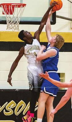 OMAR GARDNER soars above the rim to reject a shot from a Battiest player during basketball action Monday night in Fort Towson. Gardner finished with five points for the Tigers, but the Panthers had too much offense going for Fort Towson to overcome and posted a 56-39 win. Hugo News Photos / By Bob Hamill