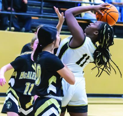 Ke’SHAWNA SCOGGINS takes the ball to the rack for two of her 20 points, leading the Hugo Lady Buff offense. (Left) CALISTA KELLEY presses the ball up the court for Hugo.