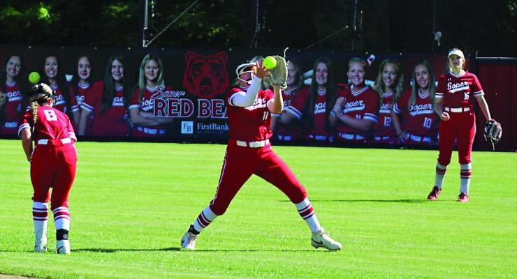 KABREY HARLESS pulls down a fly ball as her teammates, Emalyn Searles ducks and outfielder Makay Karriger back her up. The Lady Red Bears have turned a number of heads across Oklahoma with the 2025 team, currently ranked No. 4 in the State. Photo by Brian Moore