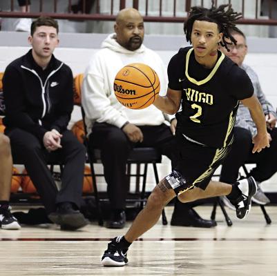 TRAVION KING (above) brings the ball down the floor for the Hugo Buffaloes and looks for someone open inside the opposing defense.