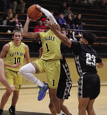 HUGO BUFFALO KADYN JONES crashes a soft spot in the Wright City Lumberjax’ defense and takes the ball to the rack for two points Monday night. Following Jones into rebound position is teammate Jayka Santillan. Coach Tanner Trent’s eighth grade Buffs battled from behind to post a 30-28 win. BELOW: QUINCY SHELTON shows his quickness and puts a baseline move on a Lumberjax defender to score two points for the ninth grade Hugo Buffaloes Monday. Hugo News Photos / Stan Stamper