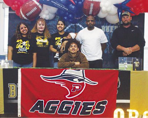 Hugo Buffalo footballer Damarion Ramsey signed his letter of intent Tuesday morning, to join the Oklahoma Panhandle State University Aggies. He is pictured with (l-r): sister Lee’Asia Ramsey, mother Leeann Markcum, sister and nephew Sha’Daja Thompson and Da’Cari Williams, father Montell Ramsey and Buffalo coach Krystopher Gross. Hugo News Photo / Krystle Taylor