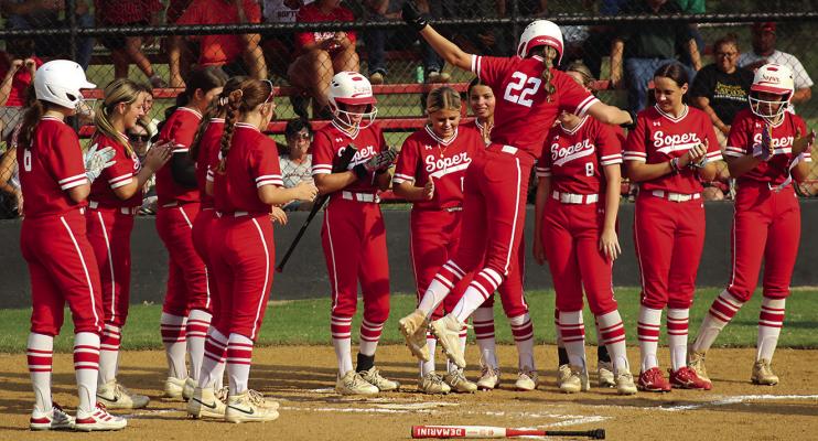 Soper’s Lady Red Bears line up at home plate to celebrate a three-run homer by Abby Johnson. Brian Moore Photo