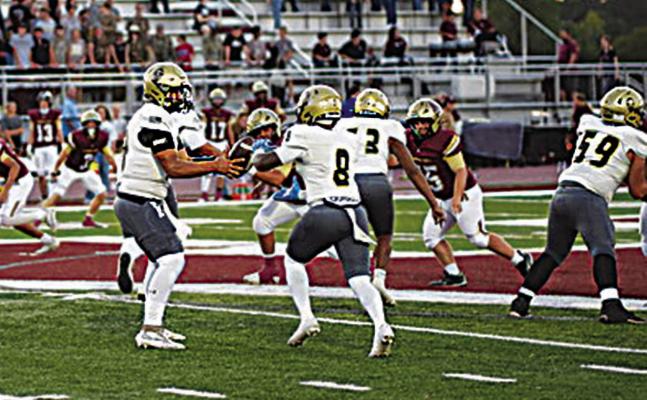 BUFFALO QUARTERBACK JAYKA SANTILLAN hands the football off to senior halfback Ja’Mari Scroggins behind O-Line blocking from Tamareon Jeffers and Draven Cook. The Wampus Cats are always tough on their home field, and the Buffaloes battled to a 27-22 victory. Photo by Ethan House Photography