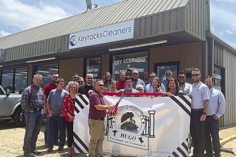The Hugo Area Cha mber of Commerce held a ribbon cutting ceremony for Keyocks Cleaners last week. Pictured: Will Smith, of Kiamichi Opportunities, cuts the ribbon while Keyrocks employees and Chamber representatives assist. The business is located at 1302 E. Jackson St.