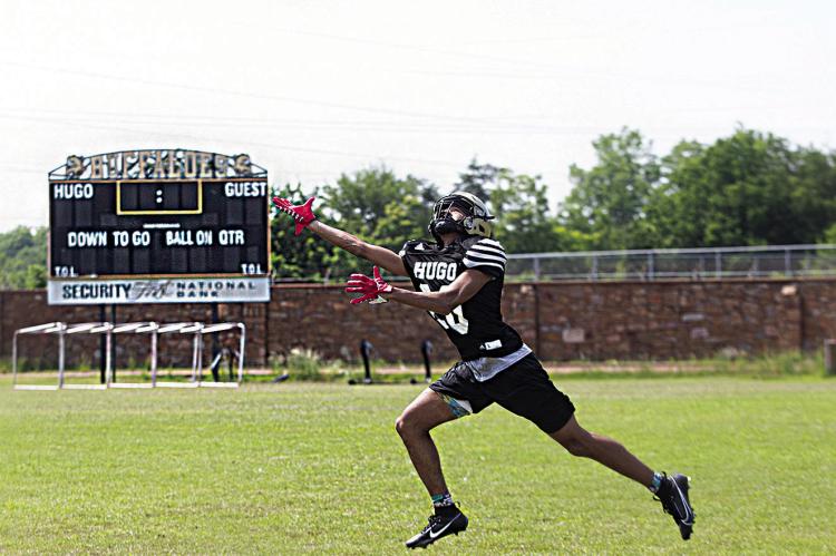 REACHING FOR THE LONG BALL during Hugo Buffalo spring football drills last week on Buff Parker Field was wide receiver K.D. Jones. Jones, a freshman, will be battling for a starting position and more game time when the Buffaloes begin their fall schedule in September. Hugo News Photo / Kelli Stacy