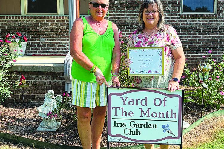 Iris Garden Club’s Yard of the Month was awarded to Gail and Shane Allen on Deer Run Rd. The beautifully maintained yard features trees, crepe myrtle’s, roses, zinnias and more. Pictured are Iris Garden Club representative Harolynn Wofford and Gail Allen.