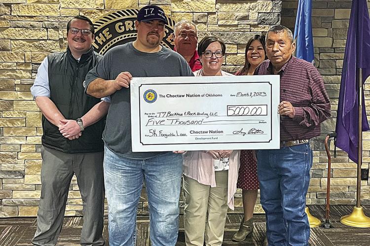 William and Ashley David Thompson, owners of T7 Backhoe &amp; Rock Hauling, accept a $5,000 check from District 8 council member Perry Thompson.