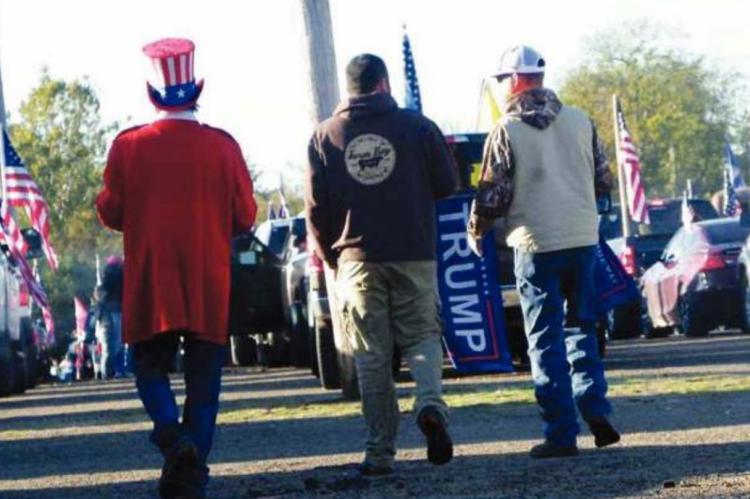A MAN DRESSED as Uncle Sam walks with two other parade participants at the Hugo Agriplex on Oct. 31 prior to rolling out as part of a Trump train. Photo Courtesy / Sonya Campbell