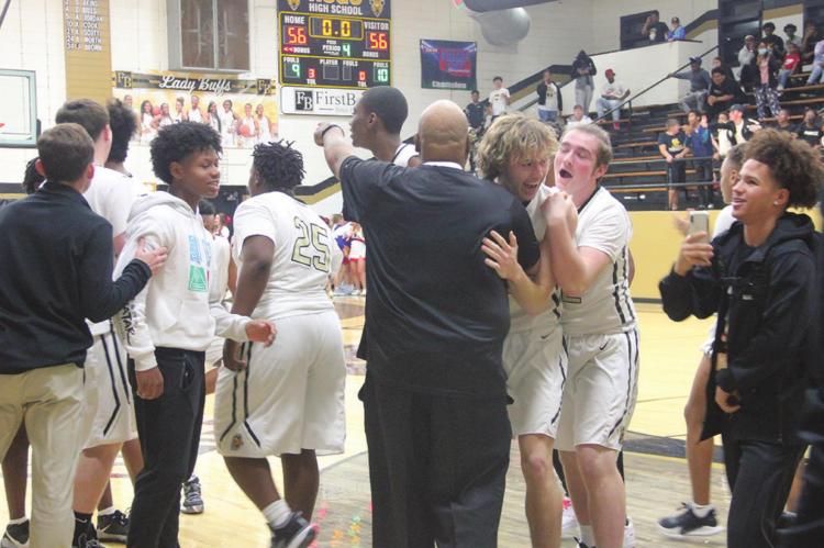 PIERSON EVANS celebrates with his teammates and hugs Coach Demontre Akins after Evans dropped the winning shot in front of the second overtime buzzer Hugo News Photos / Kelli Stacy