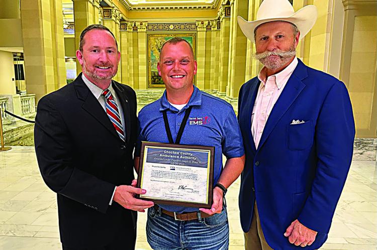 Chocta w County Ambulance Authority director Randy Springfield (center) is pictured receiving the certificate.