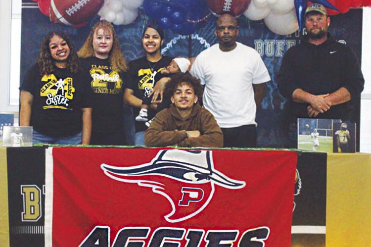 Hugo Buffalo footballer Damarion Ramsey signed his letter of intent Tuesday morning, to join the Oklahoma Panhandle State University Aggies. He is pictured with (l-r): sister Lee’Asia Ramsey, mother Leeann Markcum, sister and nephew Sha’Daja Thompson and Da’Cari Williams, father Montell Ramsey and Buffalo coach Krystopher Gross. Hugo News Photo / Krystle Taylor