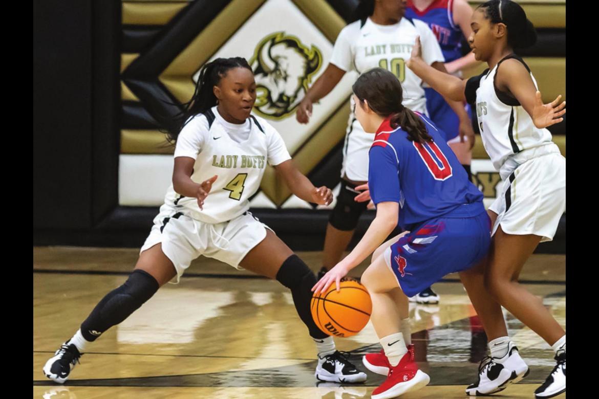 ZION BILLS, a junior for the Hugo Lady Buffs, throws a barricade in front of a Durant Lady Lion during Hugo’s first home game of the 2021 season. Assisting Bills is teammate Sha’Tiya Akins as Kelicia Cook closes in from the flank. Hugo News Photo / Bobby Hamill