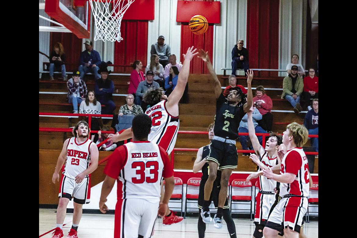MASON MOORE checks up in the paint to put up two of his 16 points scored against the Red Bears of Soper last week, despite being surrounded by the entire Soper team. Hugo News Photo / Bobby Hamill